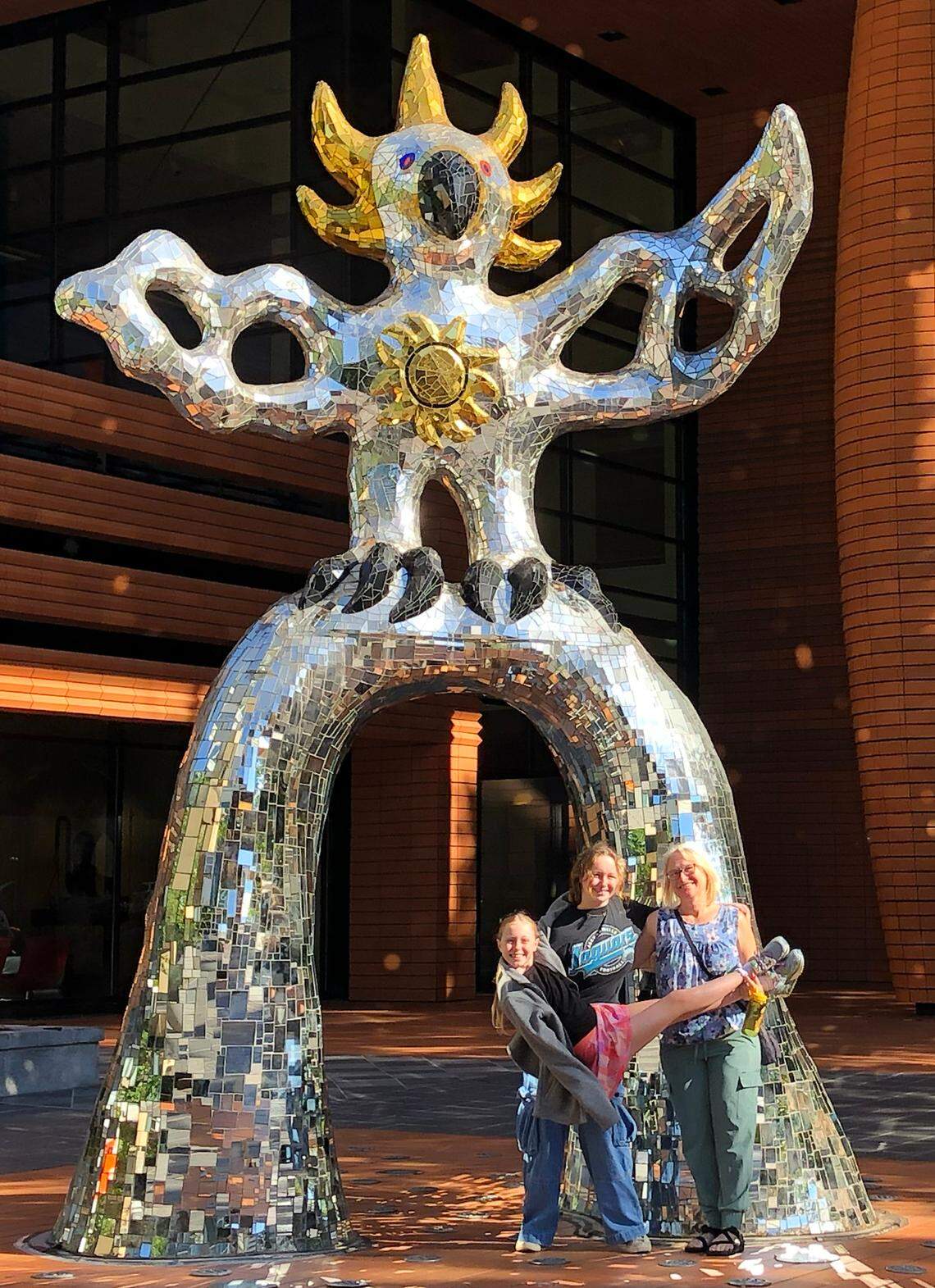 A family from Jacksonville, Fla., poses for a photograph with the Firebird sculpture outside the Bechtler Museum of Modern Art in October. The sculpture has been located on South Tryon Street in Charlotte for the past 15 years.