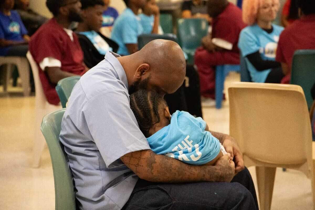 A father embraces his young son during a Proverbs226 prison event at Sussex State Prison in Virginia. July 2023.