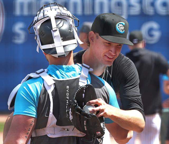 Charlotte Knights pitcher Noah Schultz, right, hugs the catcher after throwing during Wednesday’s practice at Truist Field.