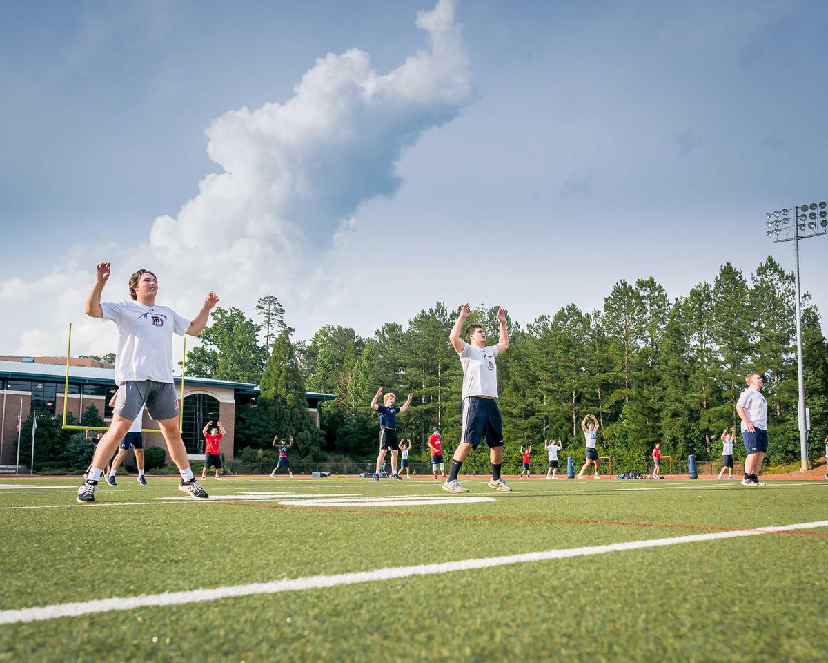 Football players at Providence Day in Charlotte were careful to remain 6 feet apart during their first practice since the coronavirus pandemic started.