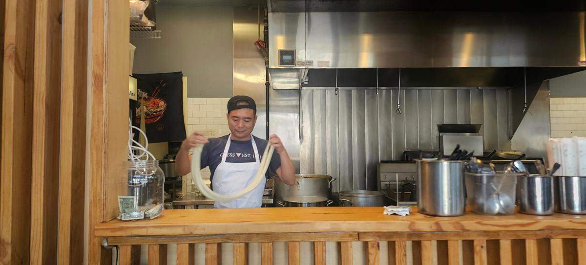 Lanzhou Hand-Pulled Noodles’ chef works on a fresh batch of its signature staple: hand-pulled noodles.