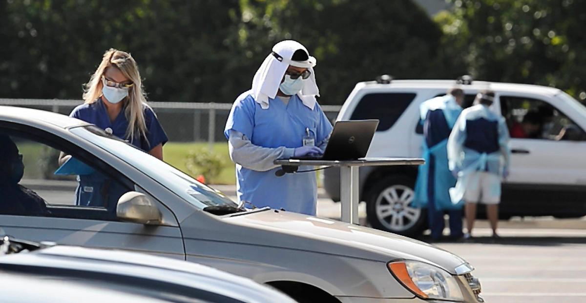 Medical personnel gather information prior to testing for COVID-19 in the parking lot at the Michael Jordan Family Medical Clinic in Charlotte on Friday, July 31, 2020.