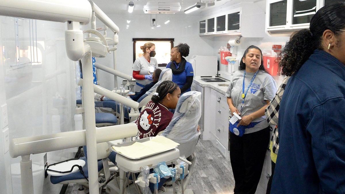 Behi Ghazisaeidi, a Mecklenburg County Public Health dental hygienist, checks with Brittany Dickens after demonstrating a dental screening with Dickens’ son, 9-year-old, Quincy Byrd. The Mecklenburg County Public Health Department sent a mobile dental health unit for dental screenings to the Calvary CARES Annual Community Impact Event 2024 at Calvary Christian Church of the Apostolic Faith in Charlotte on Saturday, Nov. 23, 1024.