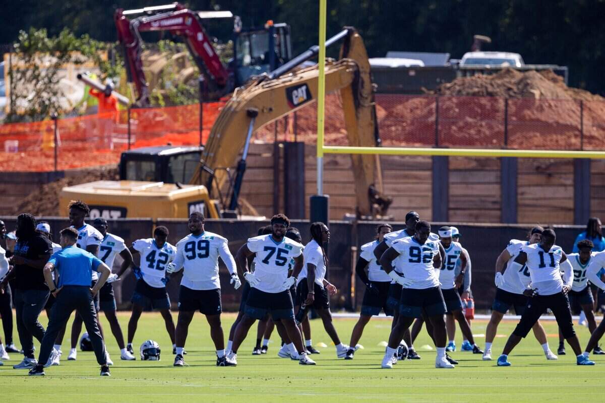 Jul 23, 2025; Charlotte, NC, USA; Construction is seen behind Carolina Panthers stretching during training camp. Mandatory Credit: Scott Kinser-Imagn Images