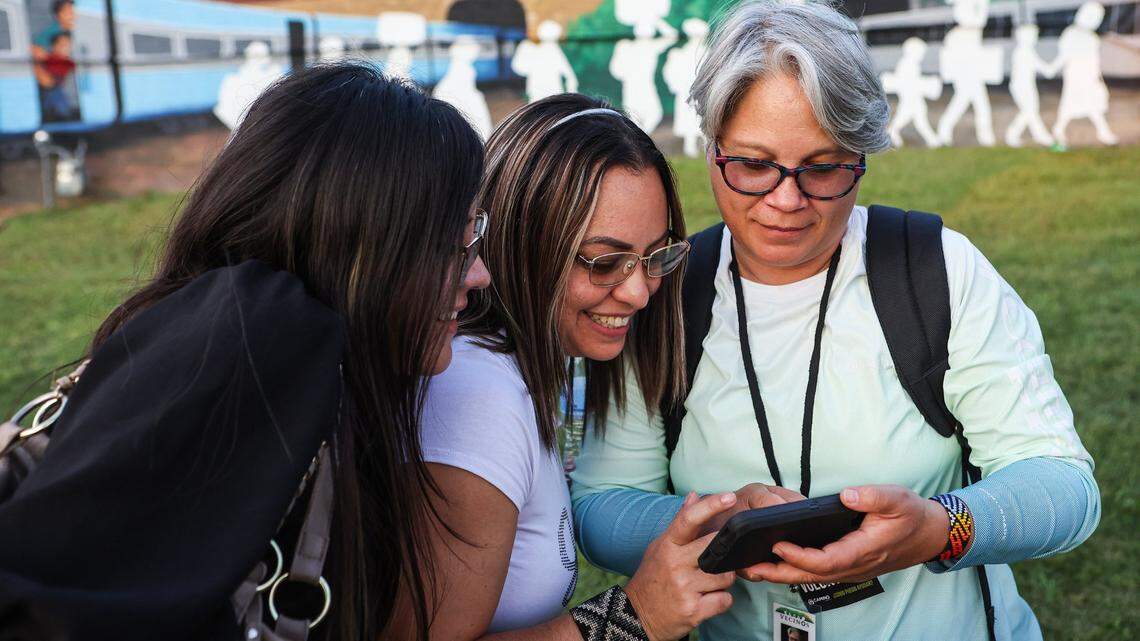Yolanda Pinzon, right, shows photos on her phone to friends during Caminos Celebra Arte & Cultura, an event celebrating the beginning of Hispanic Heritage Month, on Thursday, September 15, 2022 in Charlotte, NC.