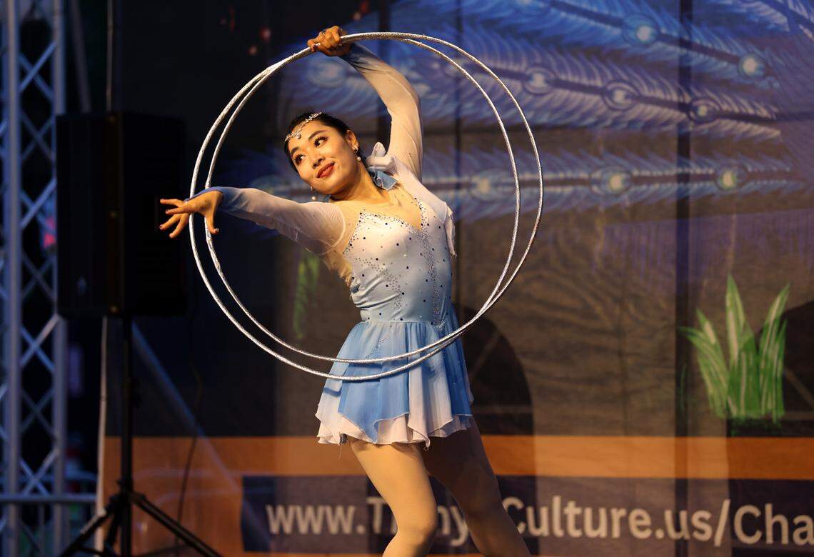 An acrobat skillfully navigates a large metal hoop as part of the Tianyu Lights Festival on Friday, April 25, 2025 at Concord Mills in Charlotte, N.C.