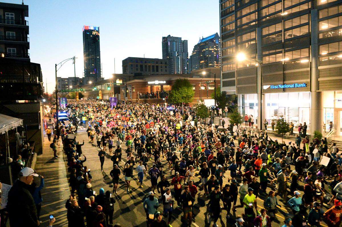 A sea of runners surges down Graham Street at the start of the Novant Health Charlotte Marathon in November 2022.