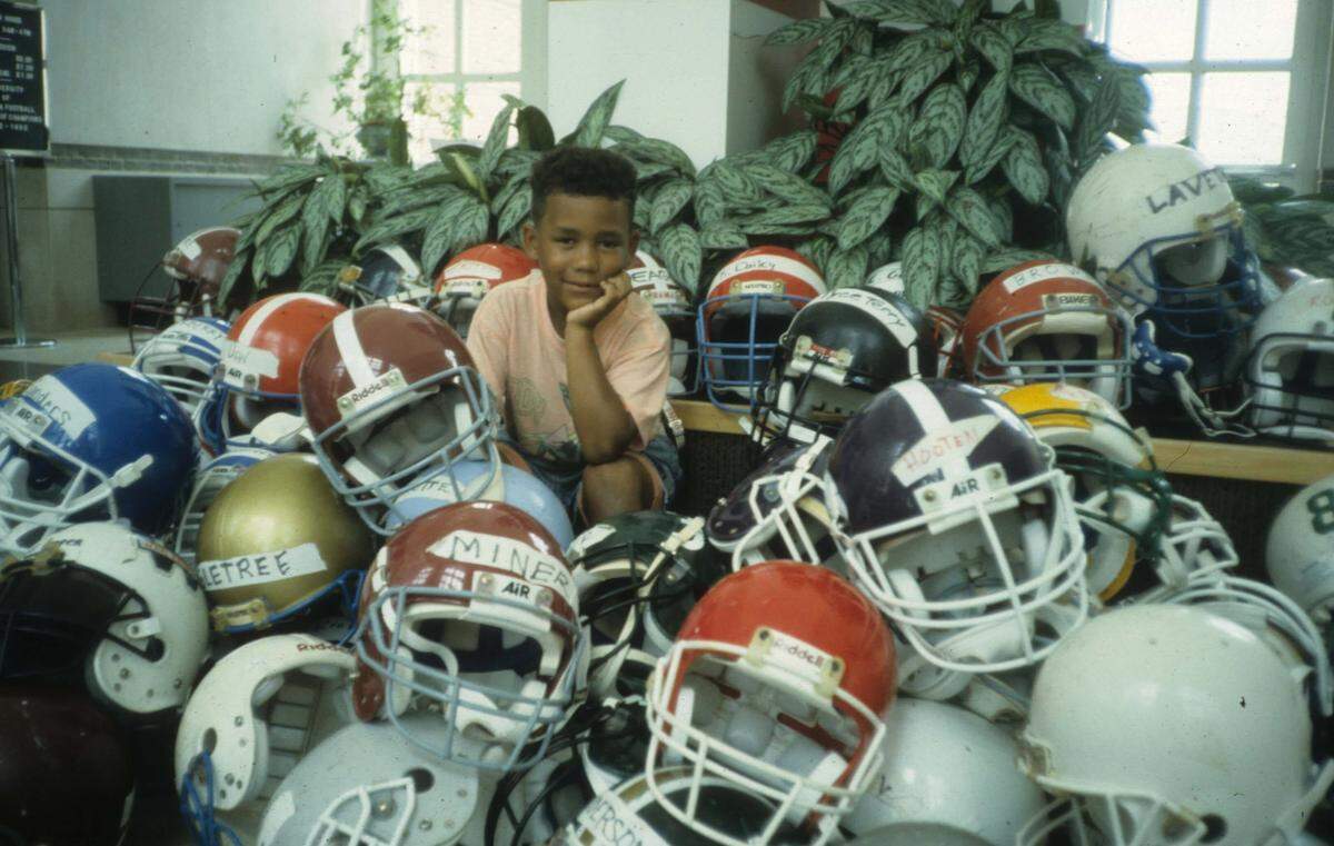 Carolina Panthers director of college scouting Jared Kirksey, pictured here as a child, poses around several helmets at the University of Alabama. Kirksey’s father, Larry, coached running backs for the Crimson Tide from 1990 to 1993. Alabama won a national championship in 1992 during Larry’s tenure as a position coach.