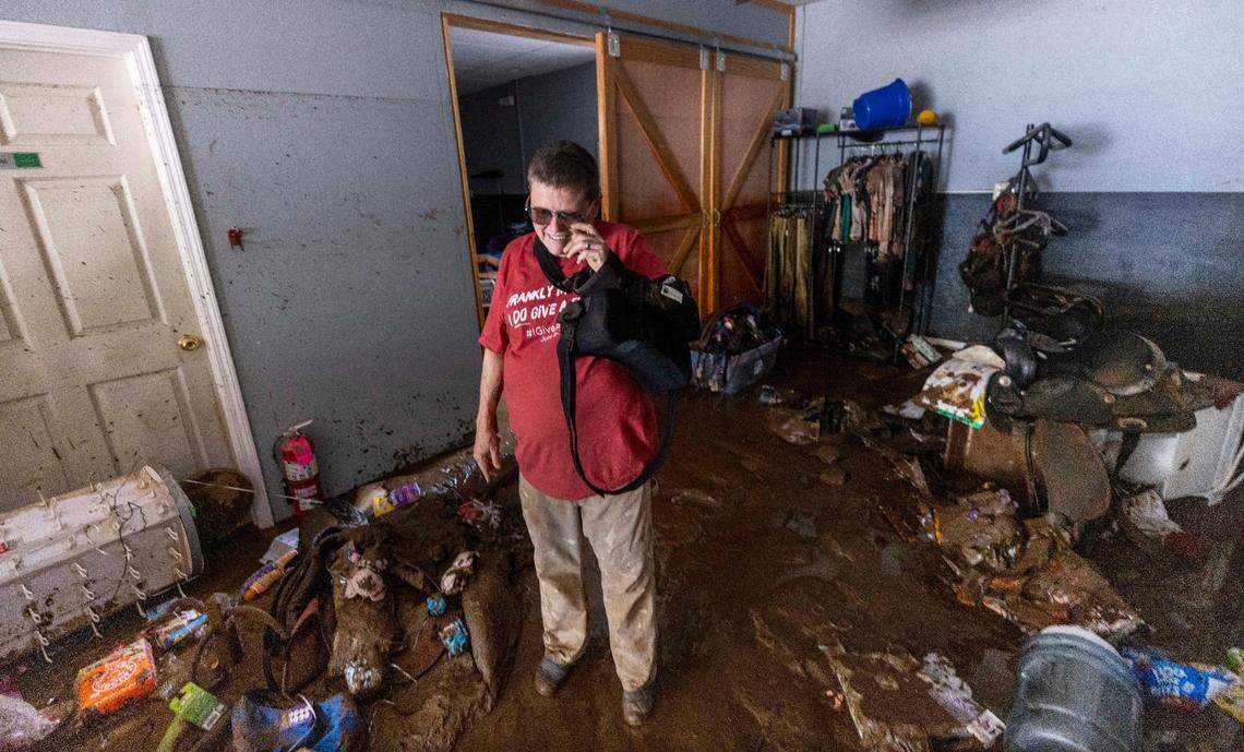 Amy Russell assesses damage to her dog training and pet food business in Clyde on Saturday, Sept. 28, 2024 after massive flooding damaged dozens of homes and businesses. The remnants of Hurricane Helene caused widespread flooding, downed trees, and power outages in western North Carolina.