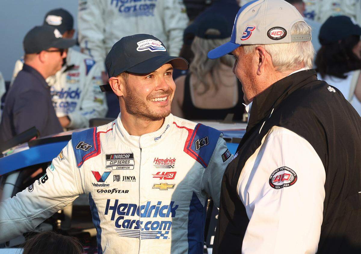 NASCAR driver Kyle Larson, left, smiles as he talks with team owner Rick Hendrick, right, in victory lane after winning the Bank of America Roval 400 at Charlotte Motor Speedway in Concord, NC on Sunday, October 13, 2024.