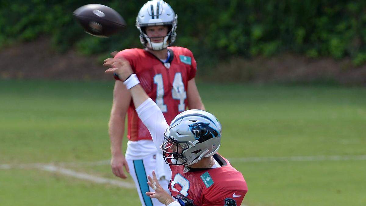 Carolina Panthers quarterback Sam Darnold, top, watches as Baker Mayfield releases a pass during practice on Monday, August 8, 2022 at Wofford College in Spartanburg, SC.