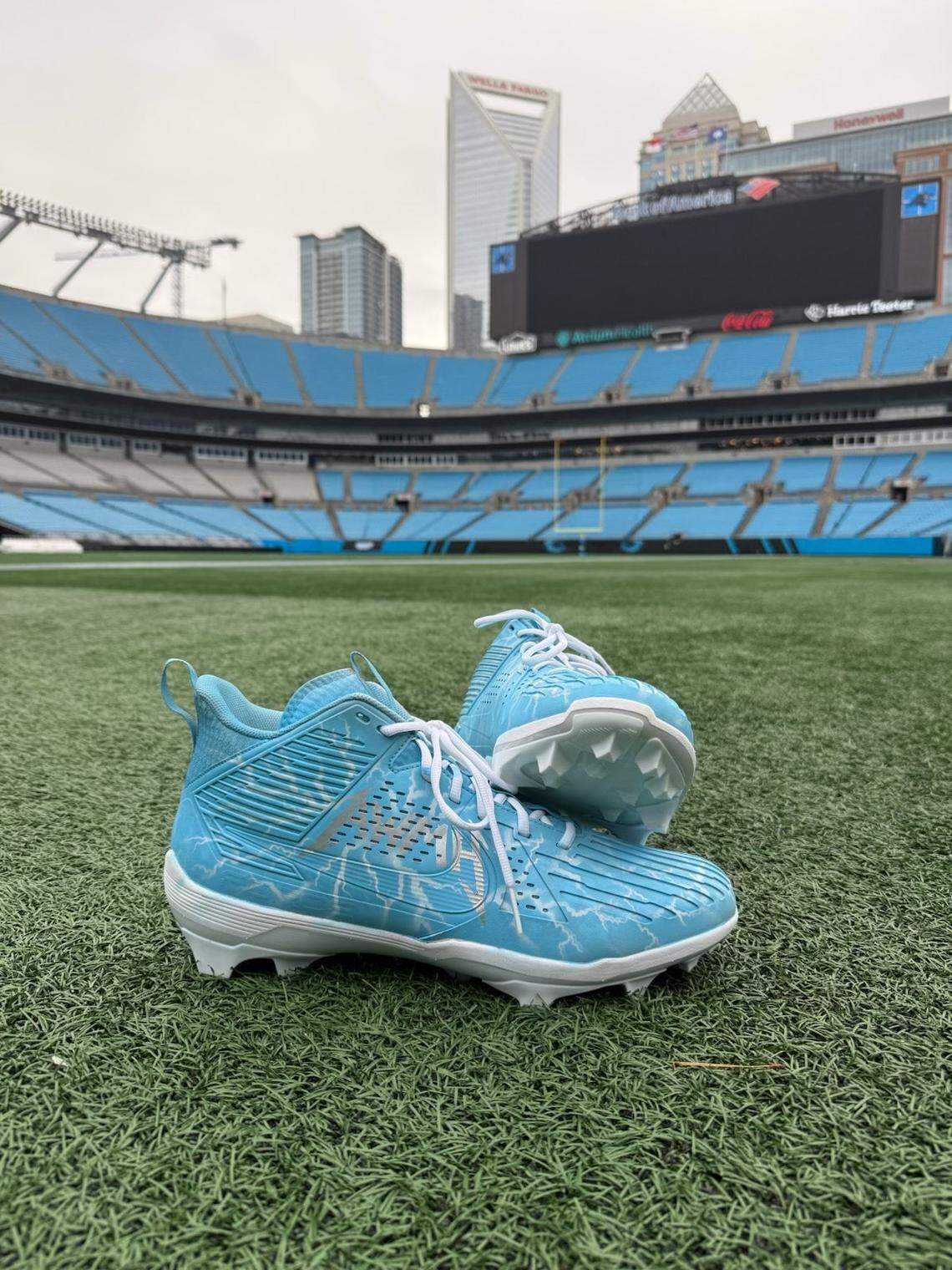 Carolina Panthers offensive lineman Austin Corbett’s “My Cause, My Cleats” cleats are displayed on the Bank of America Stadium turf.