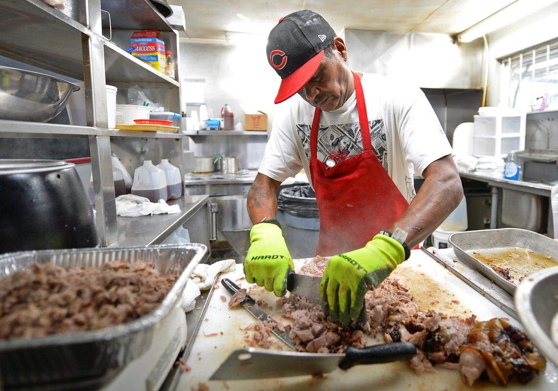 Meat cutter Charles Spikes chops up a pork shoulder at Red Bridges Barbecue Lodge in Shelby, NC, in time for the lunch crowd on Wednesday, Sept. 1, 2021.