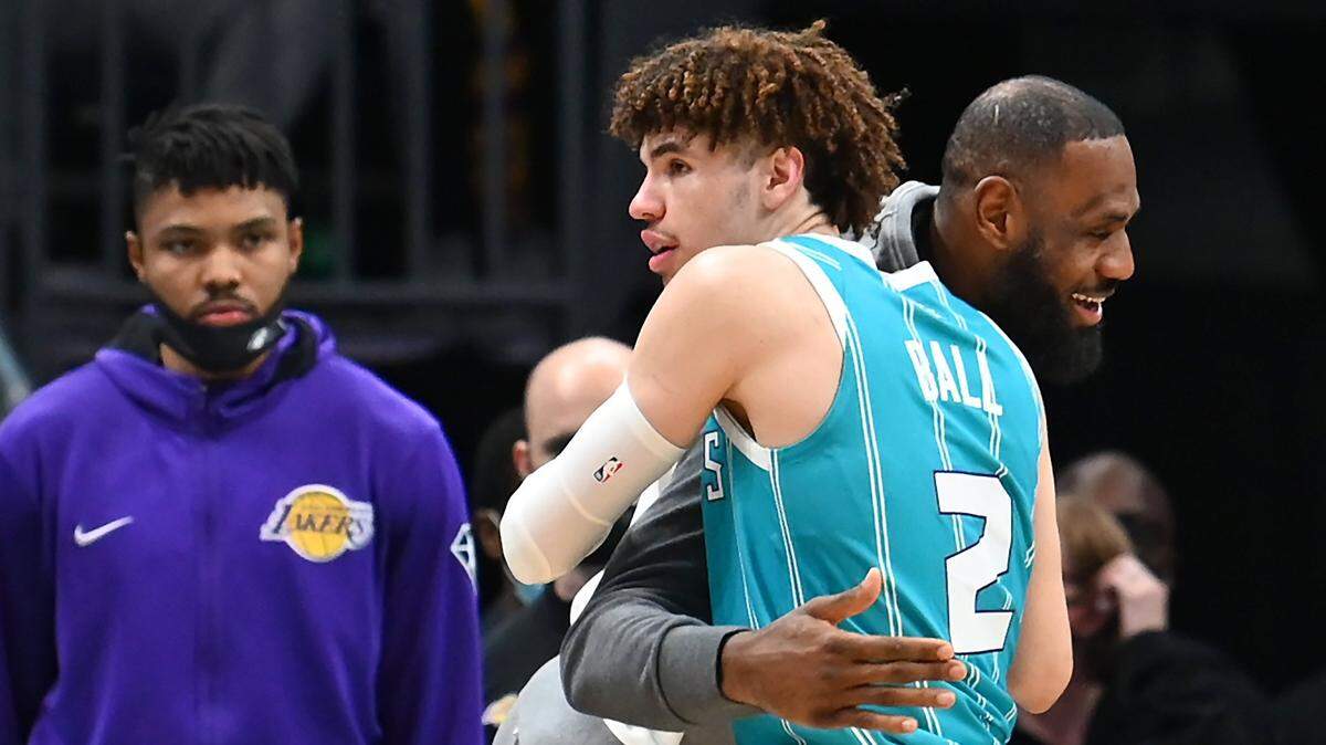 Charlotte Hornets guard LaMelo Ball, left, is hugged by Los Angeles Lakers LeBron James during a break in the action at Spectrum Center in Charlotte, NC on Friday, January 28, 2022. James did not play due to left knee soreness/effusion.