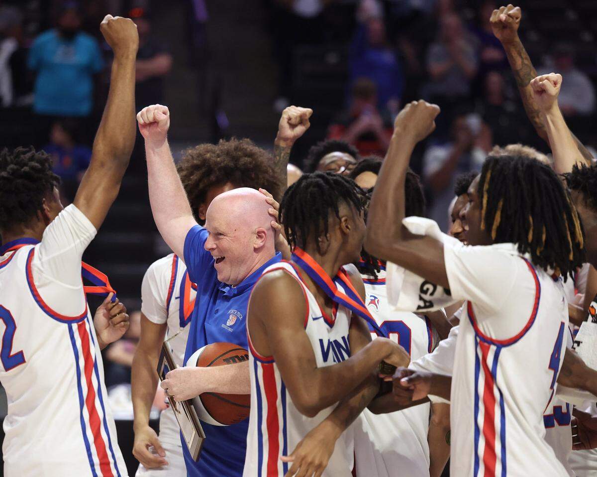 North Meck boys’ basketball coach Duane Lewis, center, celebrates the team's 57-47 victory over New Hanover with his team on March 16, 2024. The Vikings won the NCHSAA 4A state championship at Lawrence Joel Veterans Memorial Coliseum in Winston-Salem