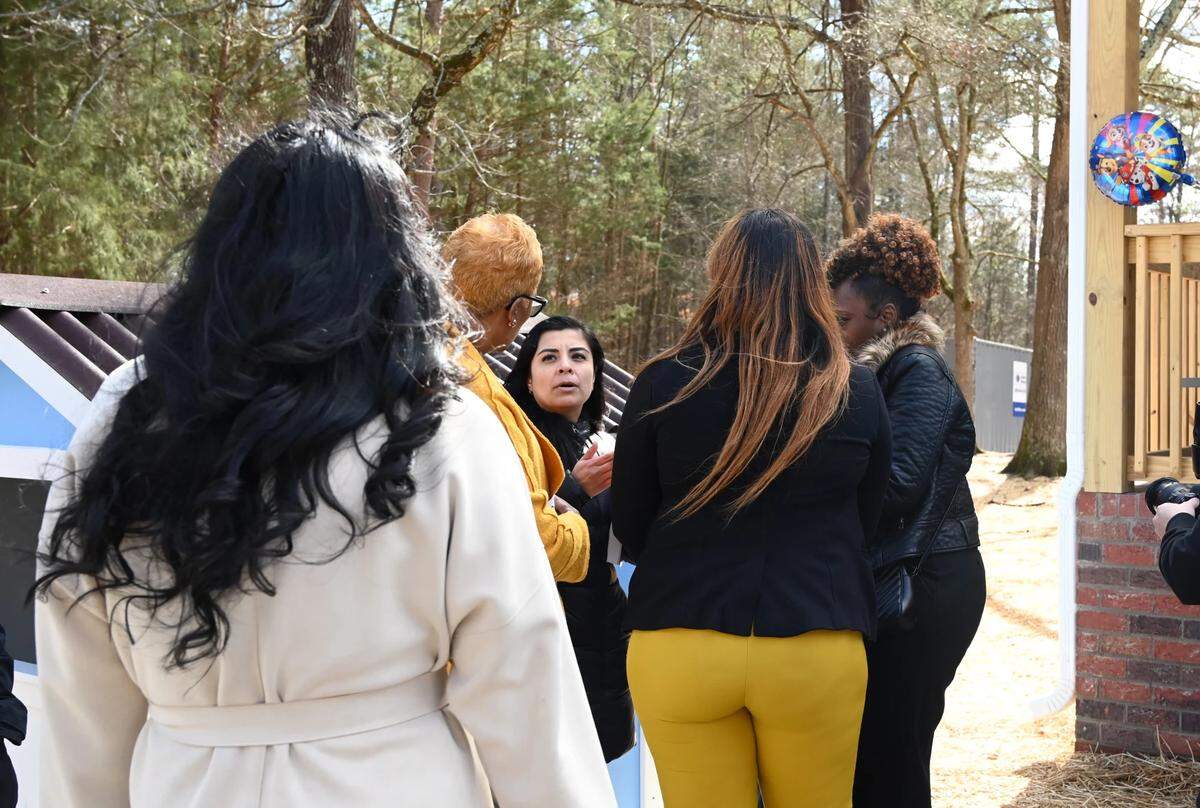Visitors wait to congratulate Yesenia Rios, center, on receiving the keys to her first home.