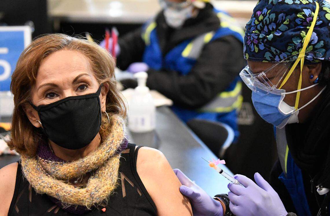Aide Blanco receives her shot at the Bank of America Stadium Atrium Health vaccine clinic on Friday, January 29, 2021. Atrium Health, Honeywell, Tepper Sports & Entertainment and Charlotte Motor Speedway formed a public-private partnership that expects to vaccinate 19,000 people at the Friday through Sunday event.