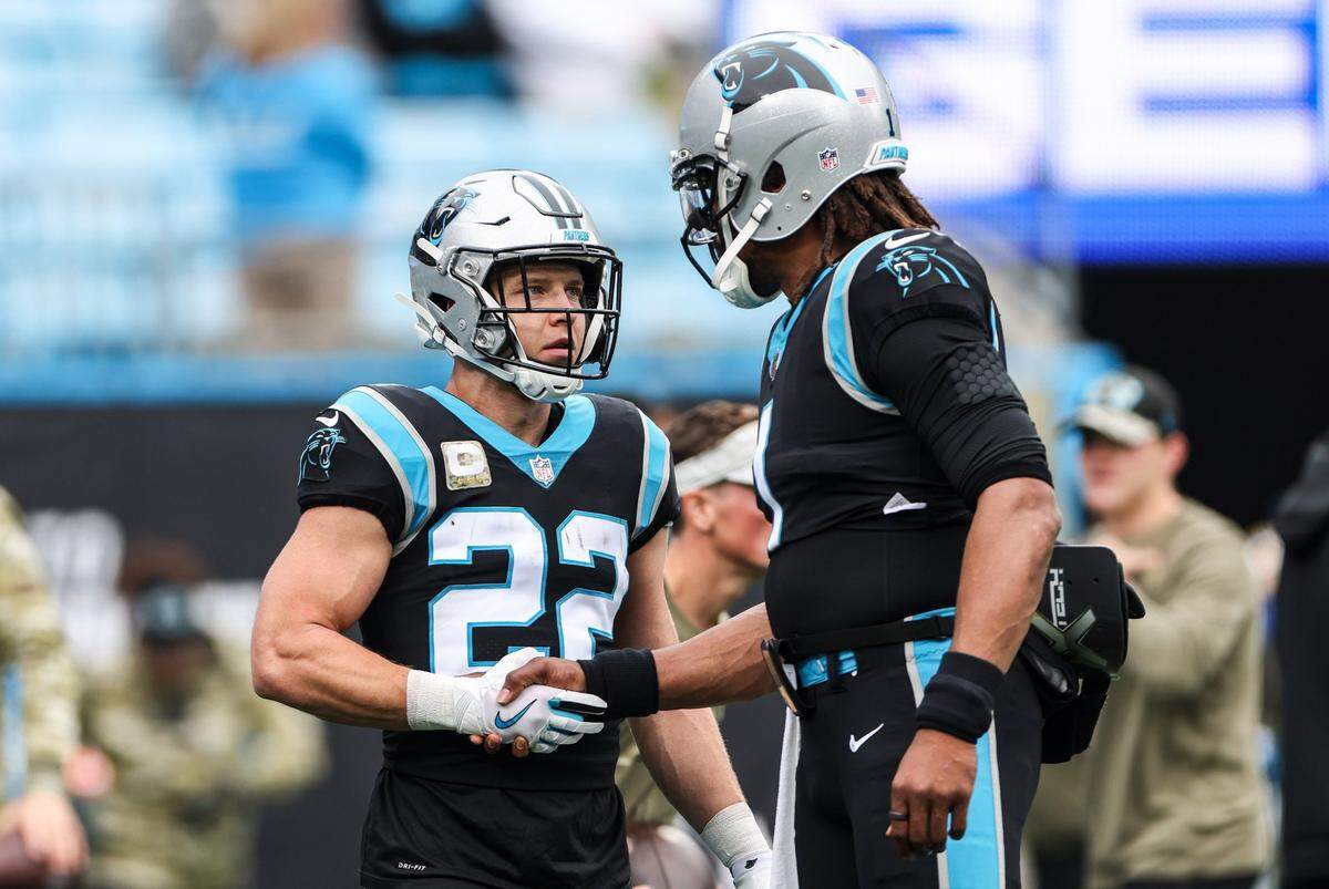 Carolina Panthers running back Christian McCaffrey, left, and Cam Newton greet each other during warm ups before the game against Washington Football Team at the Bank of America Stadium in Charlotte, N.C., on Sunday, November 21, 2021.