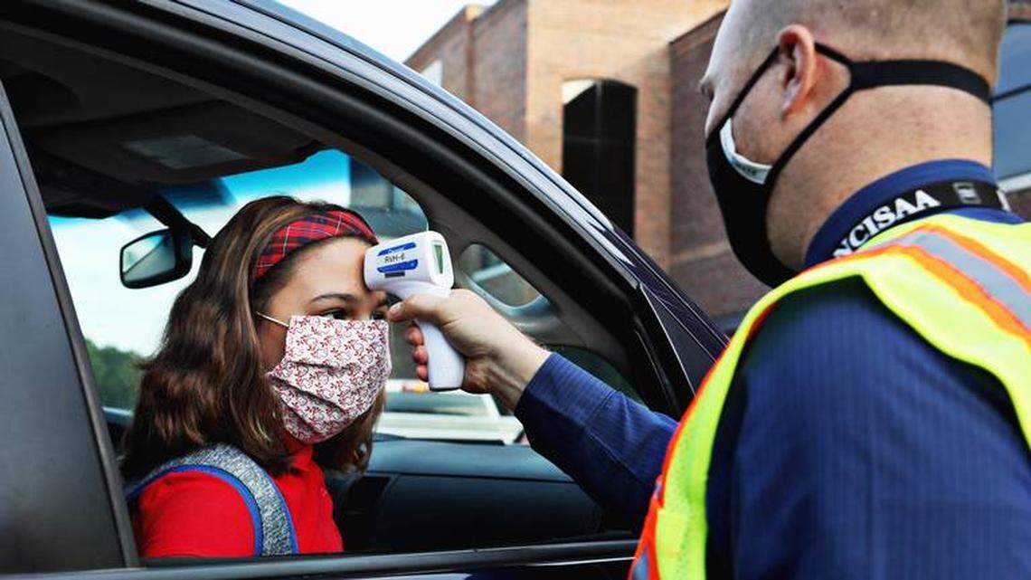 While a growing number of N.C. public schools have decided to start the year with online classes, many private schools are reopening with in-person learning. Here, seventh-grader Sophie Uvino gets her temperature checked July 22 by teacher Nathaniel Johnston before entering school at Thales Academy in Apex.