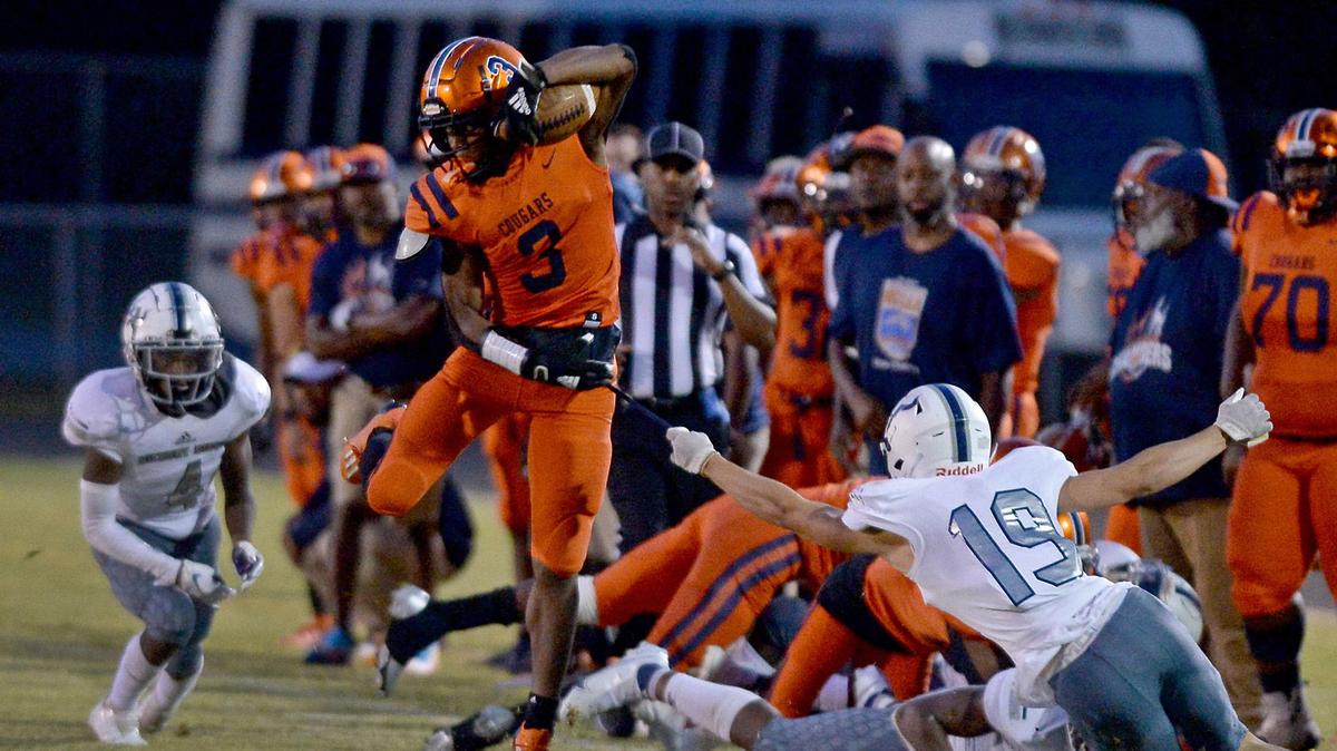 Chambers Cougars running back Daylan Smothers, center, breaks between Hickory Ridge defenders during second quarter action on Friday, September 10, 2021.