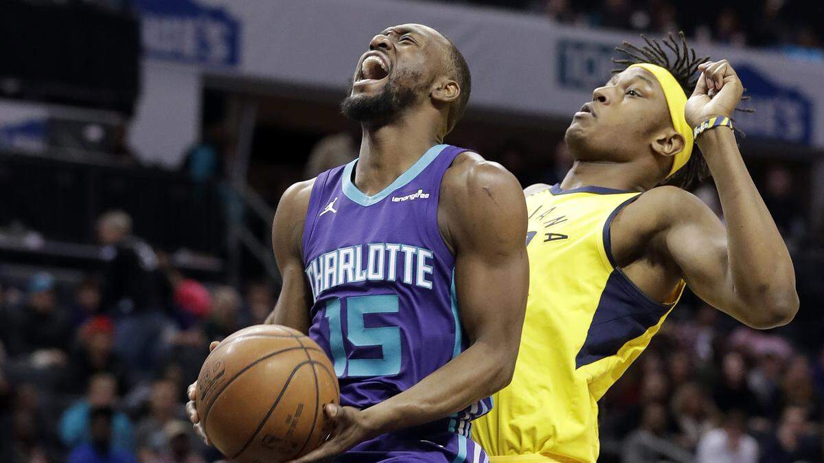 Charlotte Hornets' Kemba Walker (15) is fouled as he drives past Indiana Pacers' Myles Turner during the first half of an NBA basketball game in Charlotte, N.C., Sunday, April 8, 2018. (AP Photo/Chuck Burton)