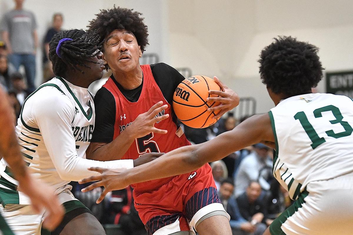 Providence Day’s Jonah Lawrence (5) drives to the basket against Christ School’s Jamari Briggs (5) and TJ Hamilton (13) during the first half. The Christ School and Providence Day School met in the NCISAA 4A Boys Basketball Finals in Raleigh, N.C. on February 24, 2024.