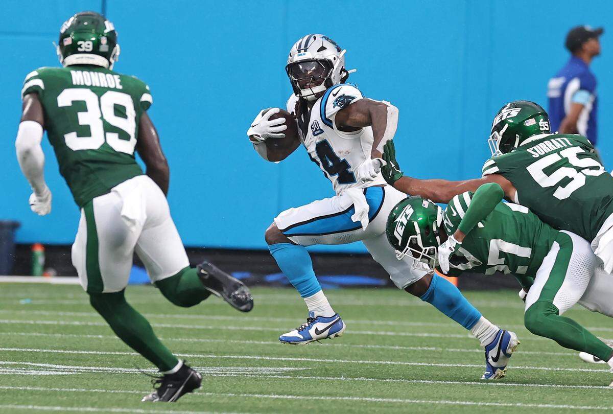 Carolina Panthers running back Mike Boone, center, breaks to the outside on a run against the New York Jets defense during second quarter action at Bank of America Stadium in Charlotte, NC on Saturday, August 17, 2024.
