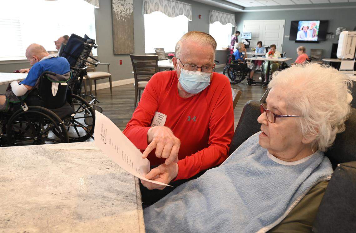 Volunteer Al Nikles, left, reads the lunch menu to resident Daisy Peterson at the Abernethy Laurels nursing home in Newton, N.C.