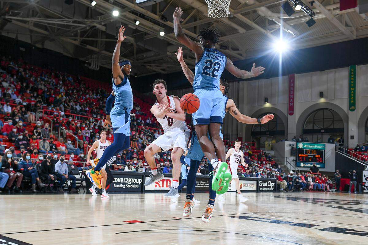 Davidson point guard Foster Loyer passes between three Rhode Island players on Saturday, Jan. 8, 2022, in a home victory for Davidson.