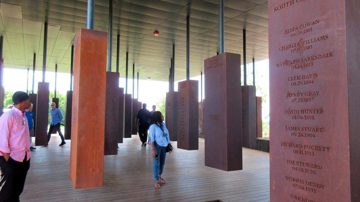 Lynching is a tragic part of the South’s past. In this April 28, 2018, file photo, visitors look at markers bearing the names of lynching victims at the National Memorial for Peace and Justice in Montgomery, Ala.