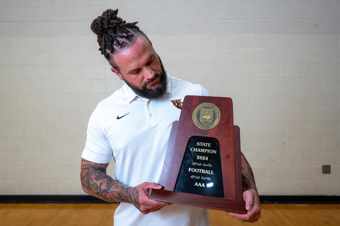 West Charlotte football coach Sam Greiner with his team’s state championship trophy from the 2024 season.