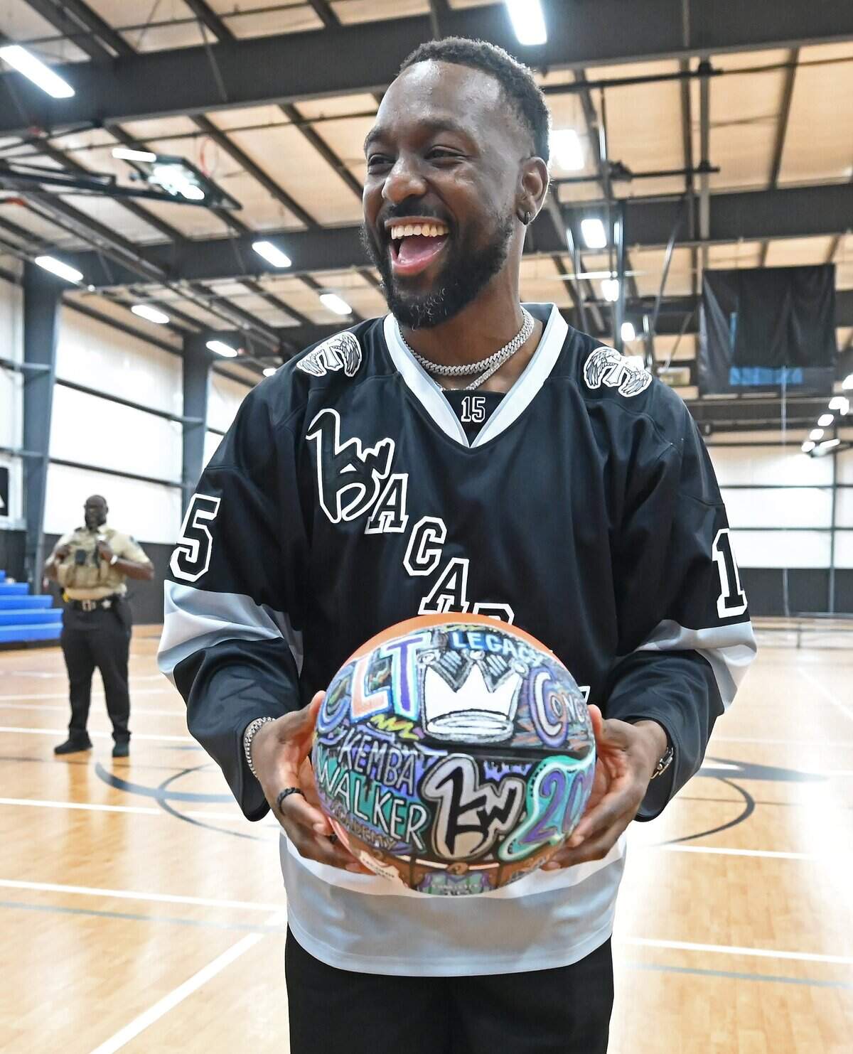 Former Charlotte Hornets guard Kemba Walker proudly holds a decorated basketball he was presented with from the Palmetto Market in Concord, NC following a press conference for his new Kemba Walker Sports Academy in Concord, NC on Friday, June 26, 2026.