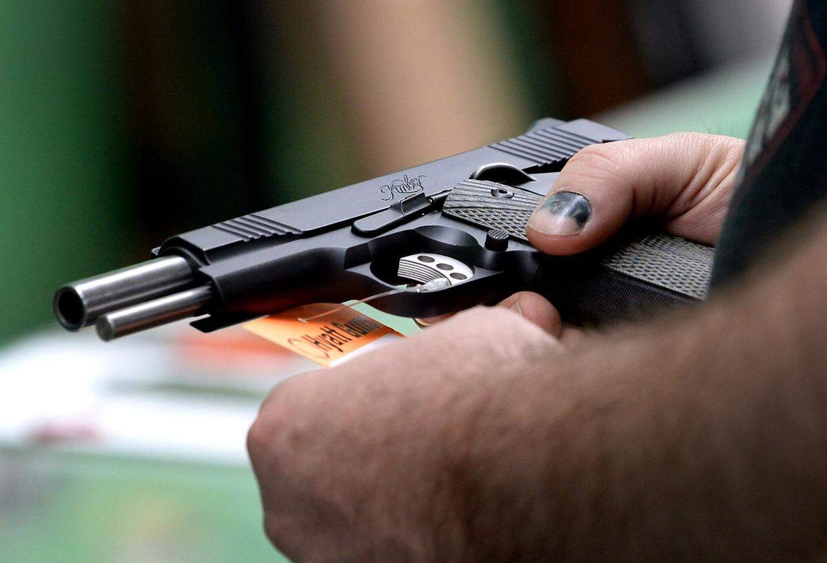A customer looks over a handgun at Hyatt Guns in Charlotte, NC on Wednesday, March 26, 2020.