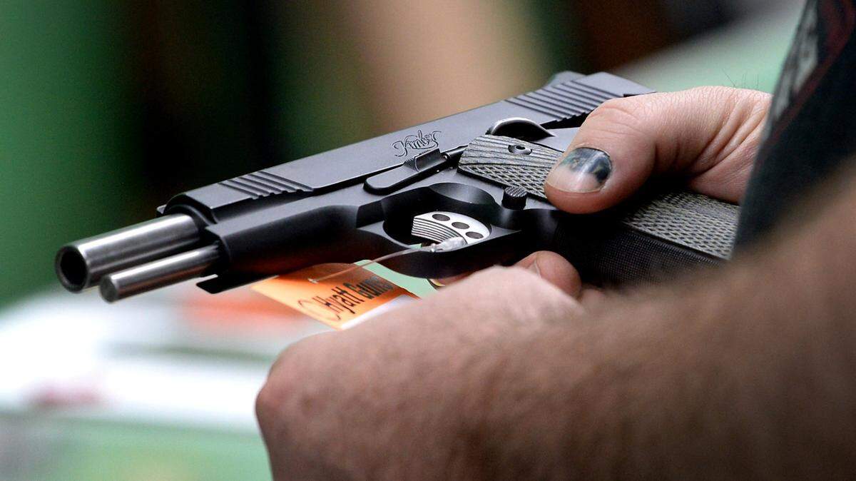 A customer looks over a handgun at Hyatt Guns in Charlotte, NC on Wednesday, March 26, 2020.