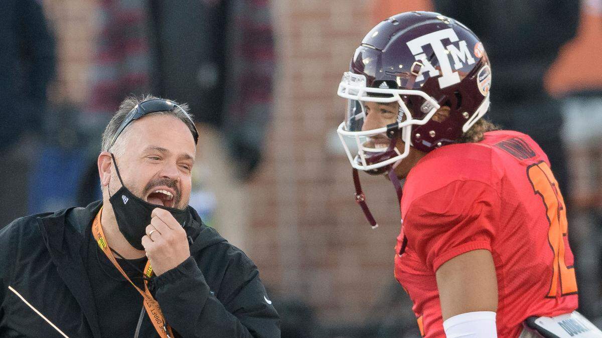 American Team head coach Matt Rhule (Carolina Panthers) jokes with American Team quarterback Kellen Mond of Texas A&M (12) during the American Team practice for the NCAA Senior Bowl college football game in Mobile, Ala., Thursday, Jan. 28, 2021. (AP Photo/Matthew Hinton)