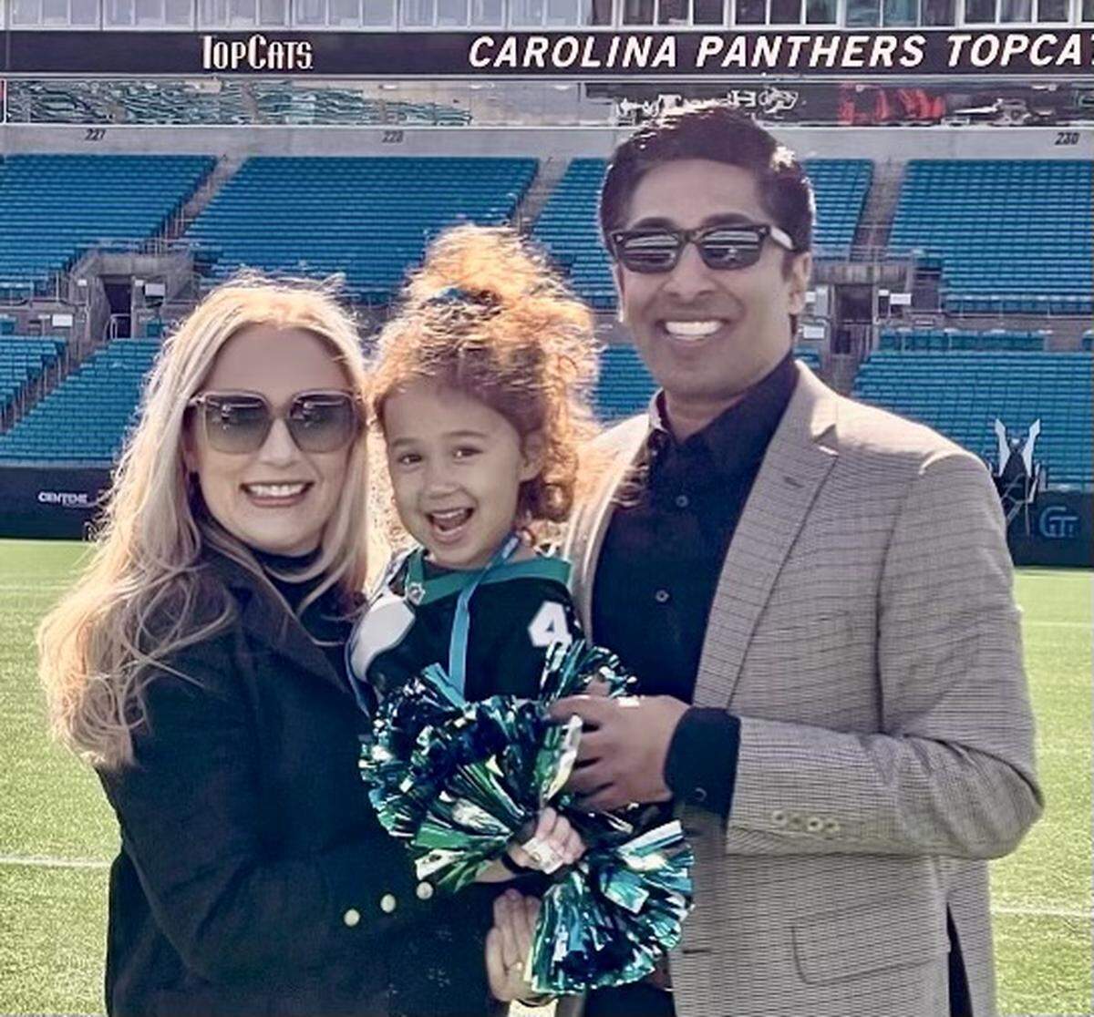 Anish Shroff, wife Faye Shroff and their daughter Athena pose for a photo at Bank of America Stadium in Charlotte. Anish Shroff is the Panthers’ new radio play-by-play announcer in 2022, replacing Mick Mixon, who retired after 17 seasons.