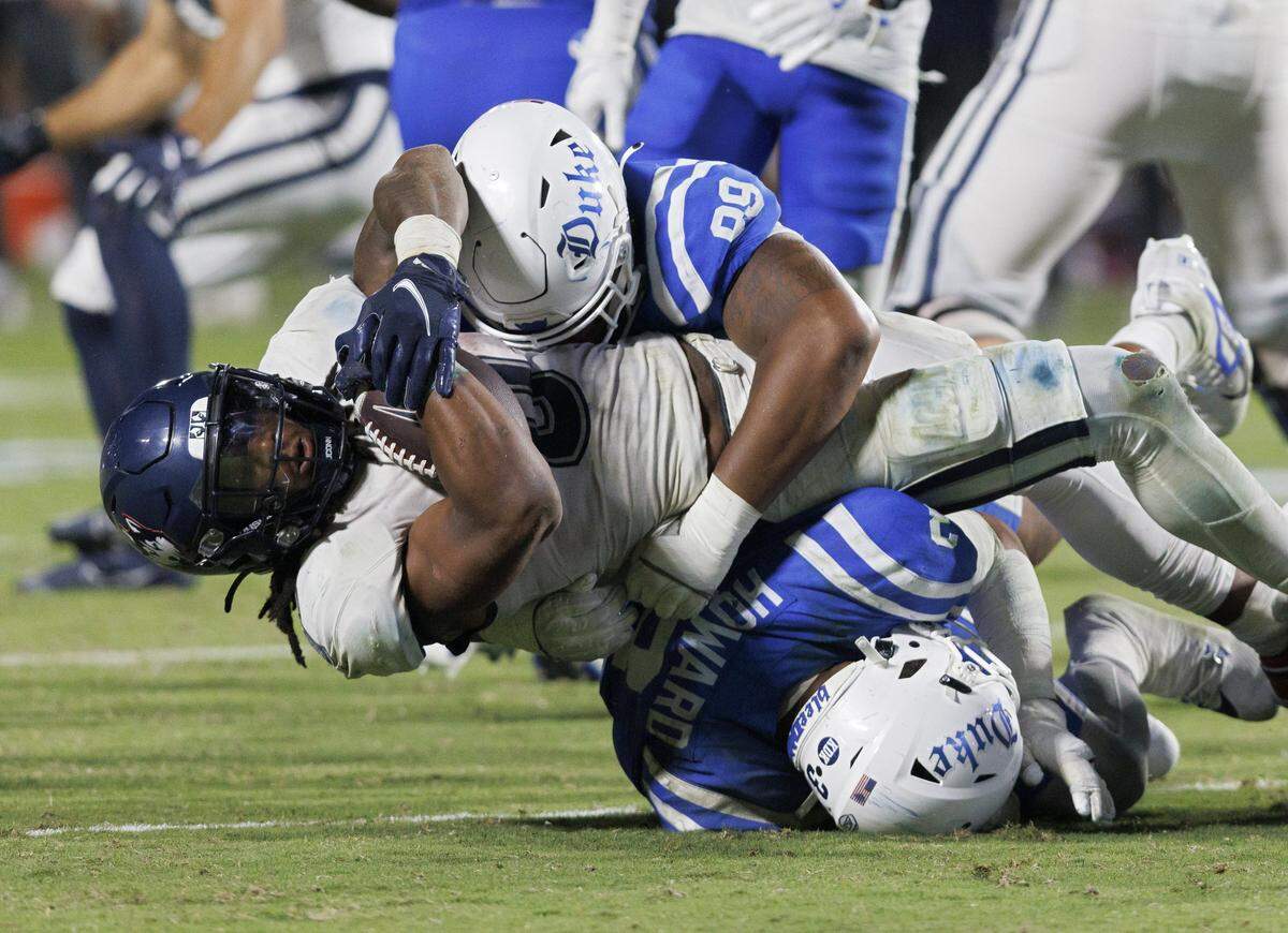 Connecticut’s Cam Edwards is brought down by Duke’s Aaron Hall during the second half of the Blue Devils’ 26-21 win on Saturday, Sept. 14, 2024, at Wallace Wade Stadium in Durham, N.C.