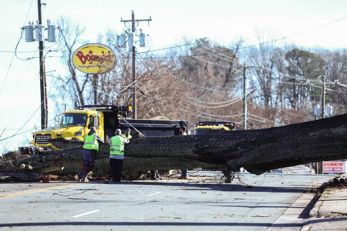 Workers cut down a downed tree on Monroe Road in Charlotte Monday morning on Dec. 30, 2024 .