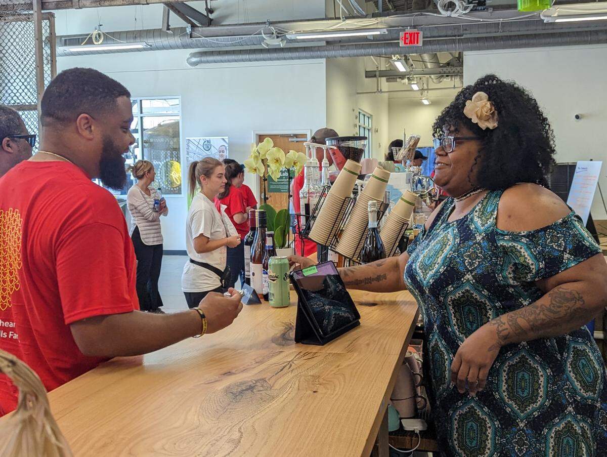 Monique Mims, the first trained barista at Change Please Coffee in Charlotte, talks with a customer at the Innovation Barn cafe at 932 Siegle Ave.