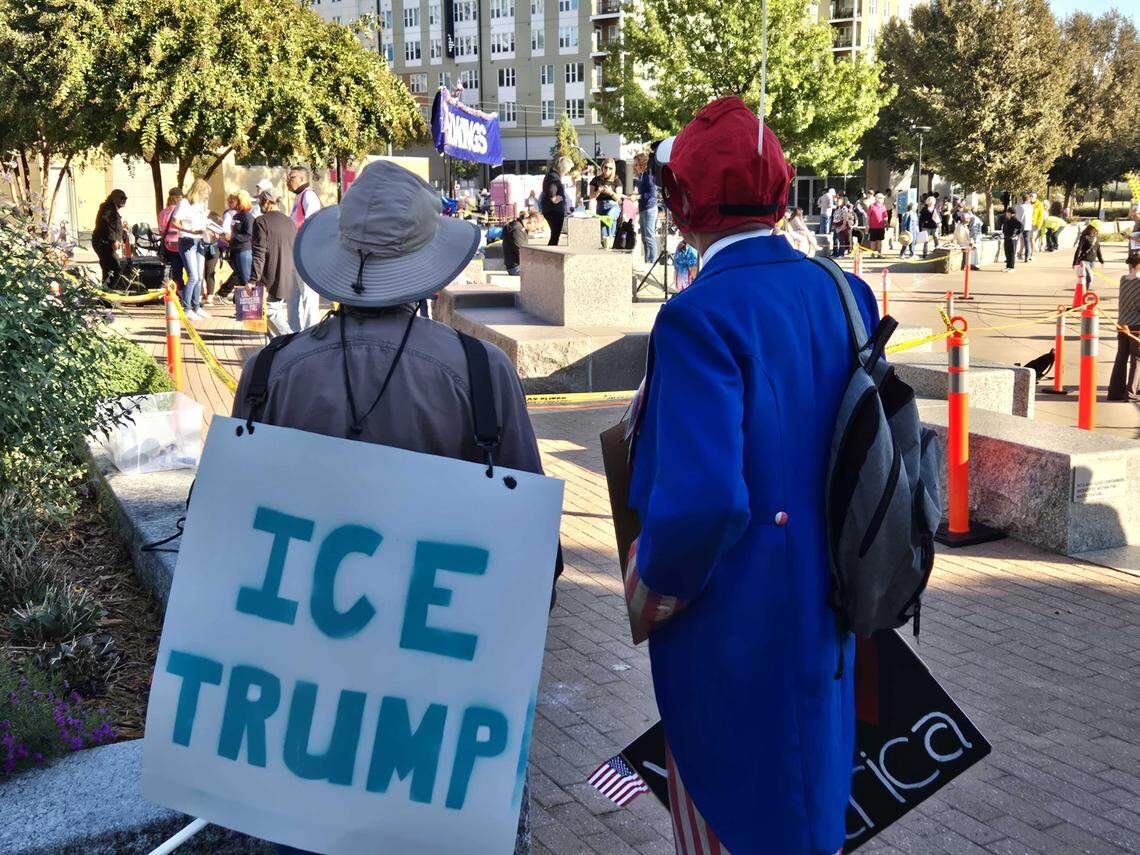 Protesters look on as the ‘No Kings’ rally in uptown Charlotte begins to set up in First Ward Park on Saturday, Oct. 18.