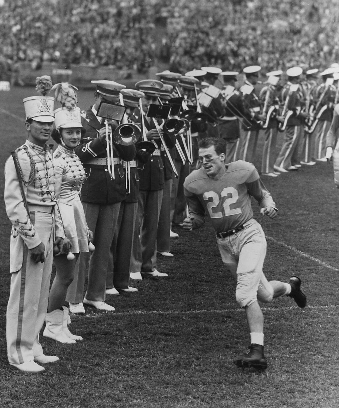 Charlie “Choo Choo” Justice runs by the band in his No. 22 uniform in the late 1940s.