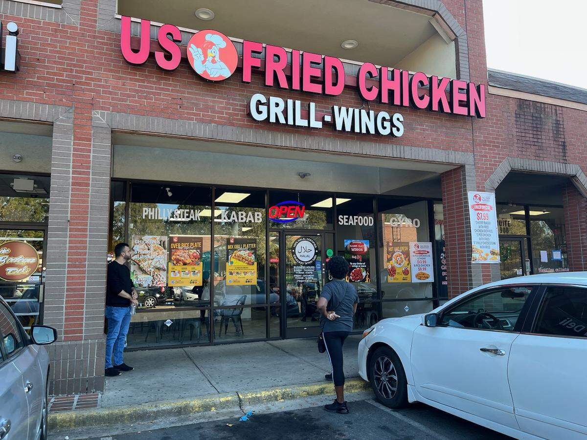 US Fried Chicken co-owner Mohammed Alweesi chats with a customer outside the restaurant’s Albemarle Road location.