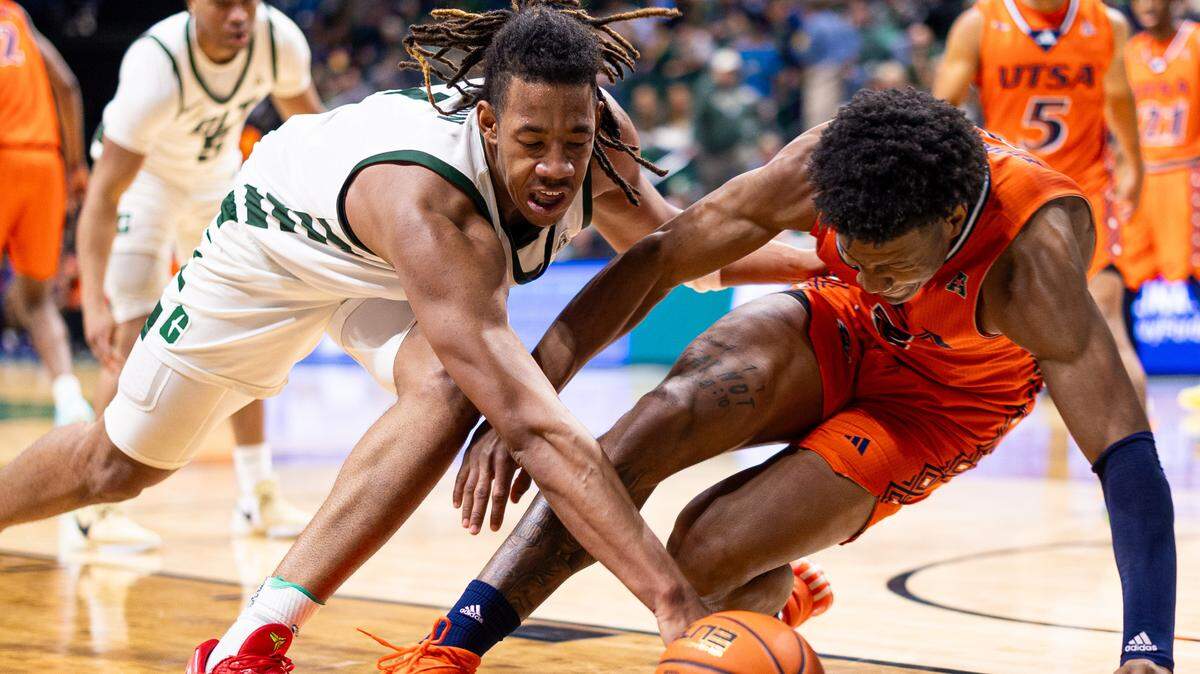 Niners Dishon Jackson, left, and Roadrunners Trey Edmonds scramble for a loose ball during a matchup at the Halton Arena in Charlotte on Thursday, February 15, 2024.