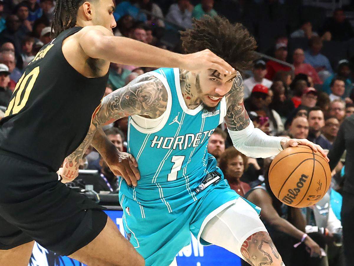 Charlotte Hornets guard LaMelo Ball, right, lowers his head as he penetrates into the lane against Cleveland Cavaliers guard Jaylon Tyson during action at Spectrum Center in Charlotte, North Carolina, on Wednesday, Jan. 21, 2026. The Cavaliers defeated the Hornets 94-87.