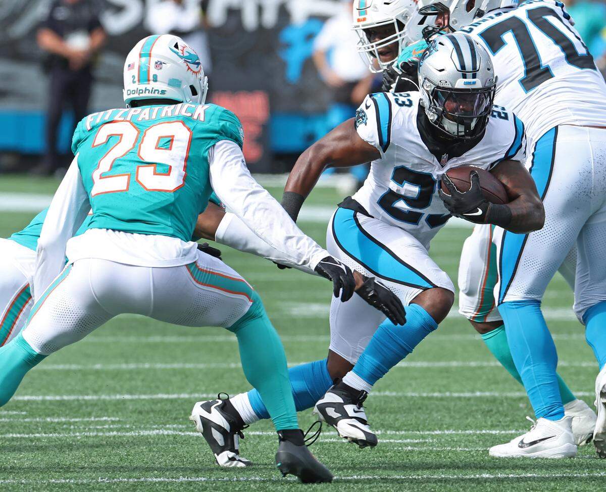 Carolina Panthers running back Trevor Etienne, right, breaks back to the inside on a run as Miami Dolphins safety Minkah Fitzpatrick, left, reacts during action on Sunday, October 5, 2025 at Bank of America Stadium in Charlotte, NC. The Panthers defeated the Dolphins 27-24.