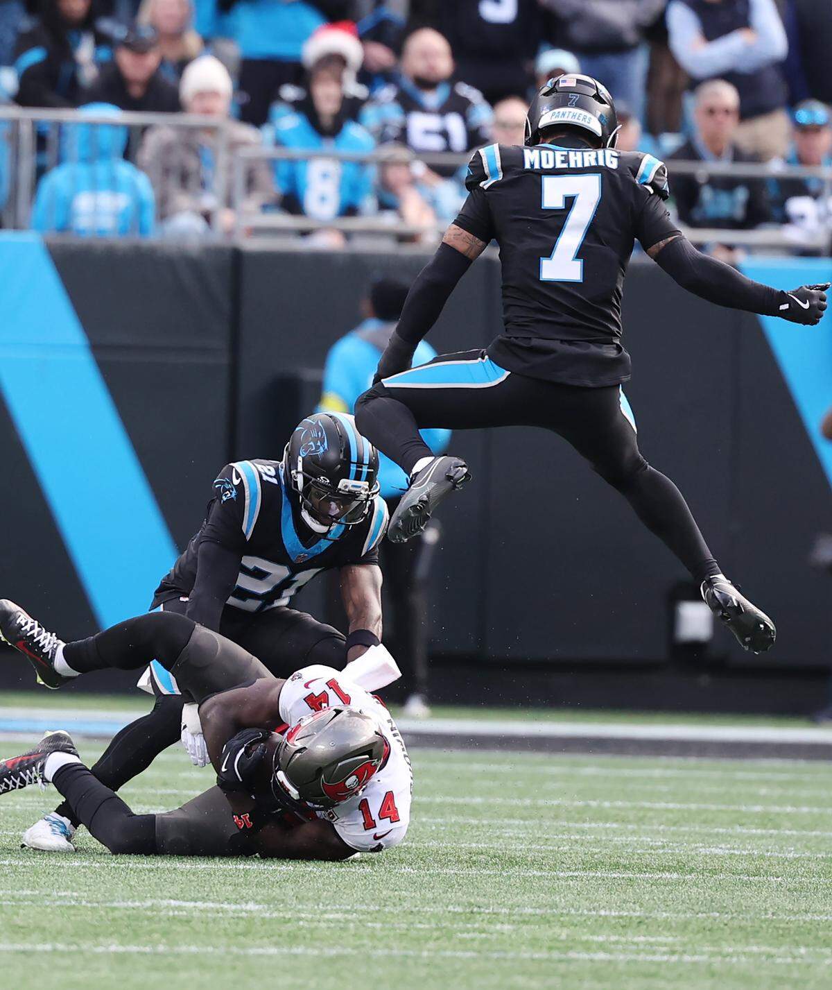 Carolina safety Tre'Von Moehrig jumps over Tampa Bay’s Chris Godwin Jr. as Panthers Nick Scott makes the tackle on Dec. 21, 2025, at Bank of America Stadium. The two teams play again at 4:30 p.m. Saturday.