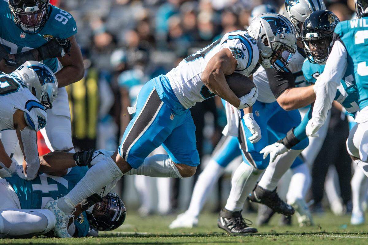 Carolina Panthers running back Chuba Hubbard (30) runs the ball against Jacksonville Jaguars linebacker Travon Walker (44) in the second quarter at EverBank Stadium.