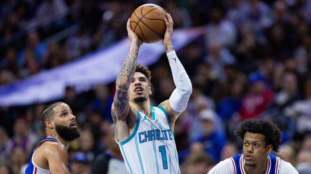 Charlotte Hornets guard LaMelo Ball (1) drives between Philadelphia 76ers forward Caleb Martin (L) and guard Jeff Dowtin Jr. (R) during the second quarter at Wells Fargo Center.