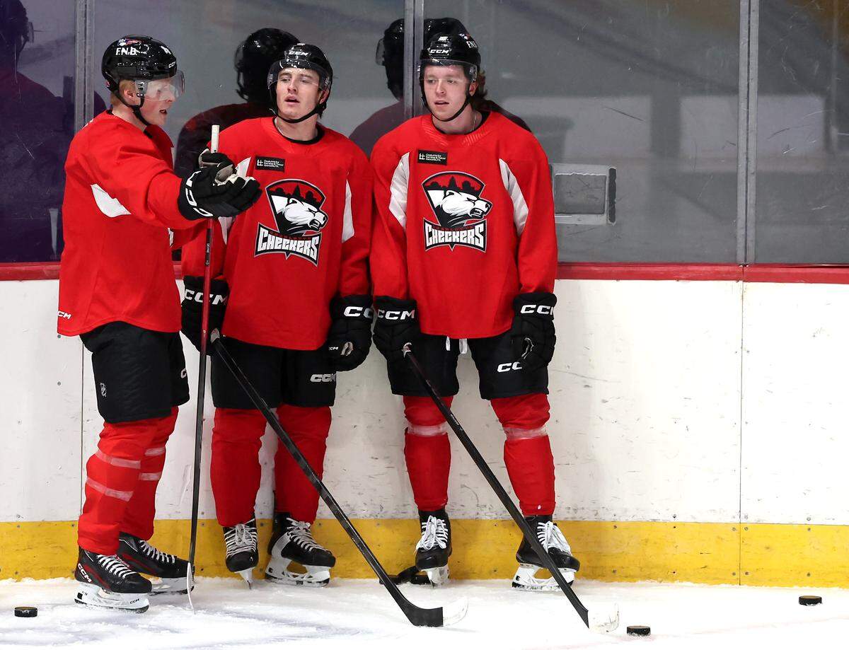 Charlotte Checkers Ryan McAllister, right, waits along the board with his teammates during practice at BoJangles Coliseum in Charlotte, NC on Thursday, October 9, 2025.