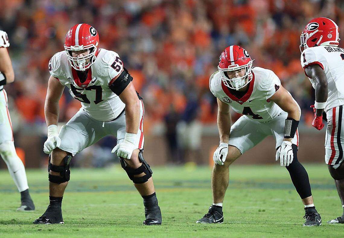 Monroe Freeling (57) and Oscar Delp (4) of the Georgia Bulldogs line up against the Auburn Tigers during a 2025 game.